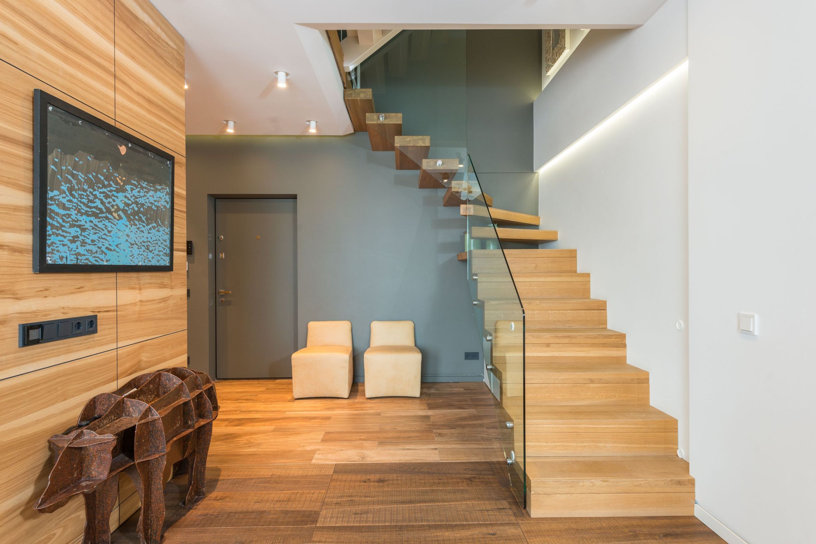 Floating oak staircase beside an oak-panelled wall
