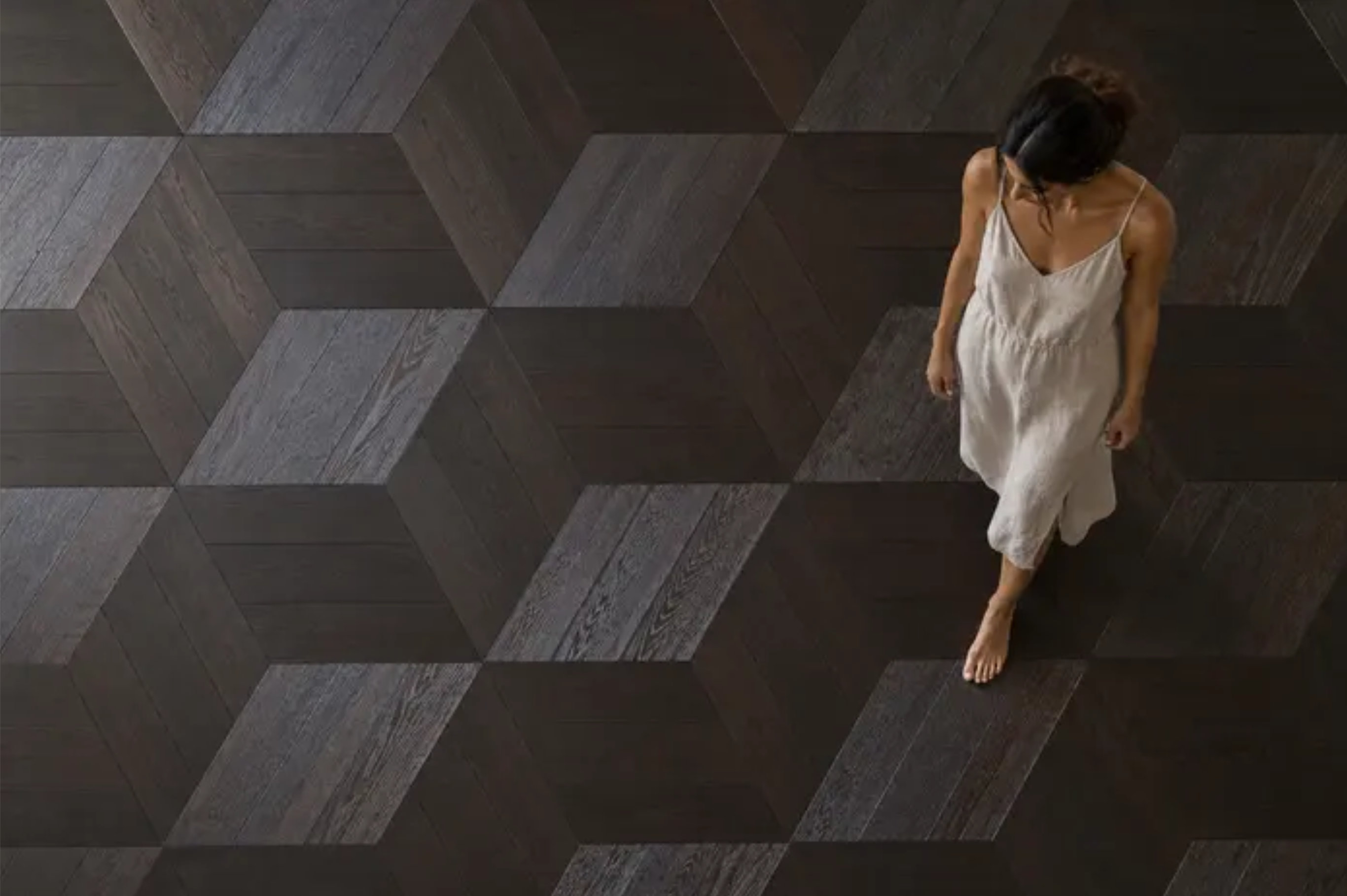Woman walking across a dark oak parquet floor